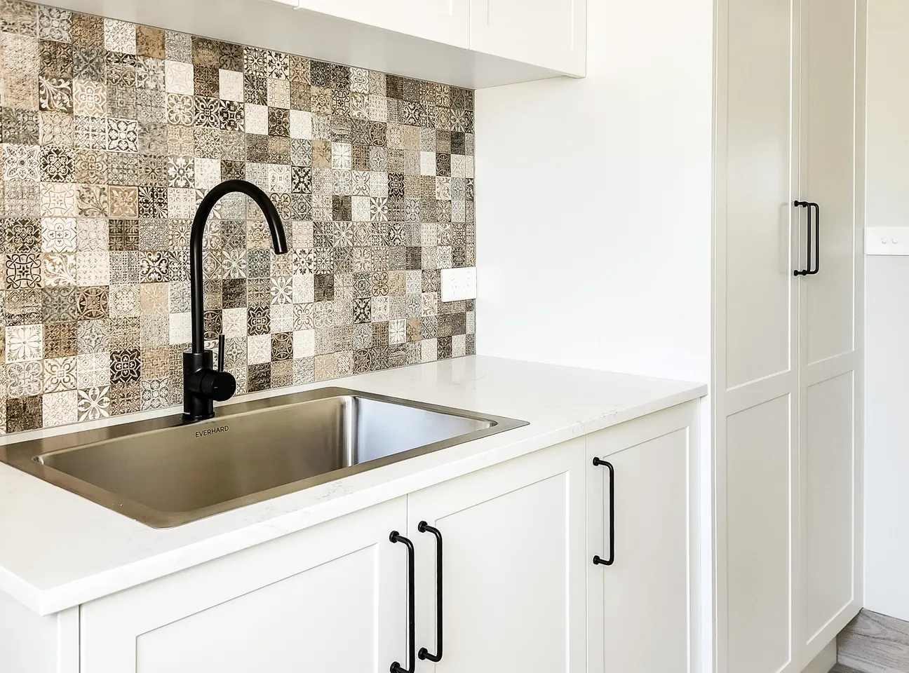 Laundry with patterned tile splashback