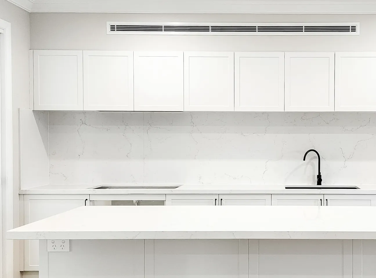 White kitchen with stone island bench