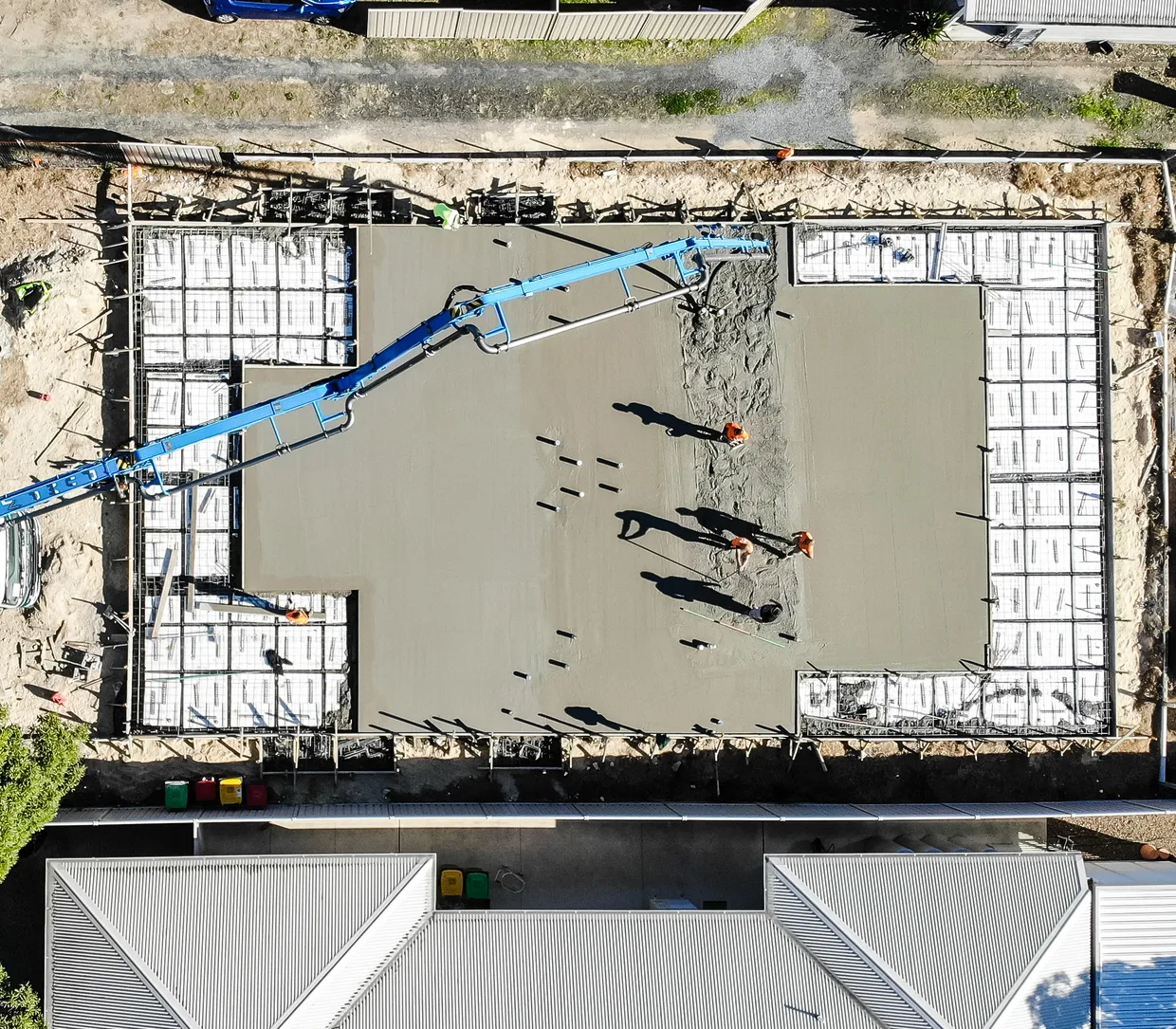 Drone view of a concrete slab being poured on a BuildTec Homes building site